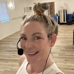 Holly Sanders, owner and trainer at Breathe Studio, smiling in the studio.